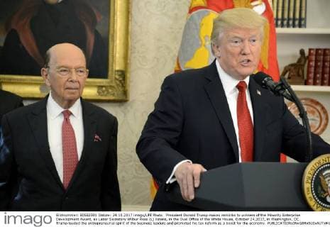 President Donald Trump makes remarks to winners of the Minority Enterprise Development Award, as Labor Secretary Wilbur Ross (L) listens, in the Oval Office of the White House, October 24,2017, in Washington, DC. Trump lauded the entrepreneurial spirit of the business leaders and promoted his tax reform as a boost for the economy.  WAP20171024503 MIKExTHEILER
