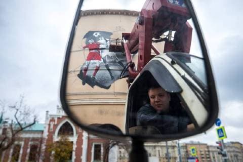 MOSCOW, RUSSIA - OCTOBER 28, 2017: A crane driver seen while artists paint a graffiti on a wall in Moscow s Zatsepsky Val Street ahead of the 2018 FIFA World Cup. Sergei Bobylev TASS  TS066E7D