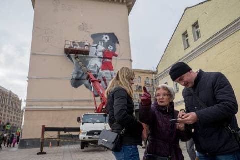 MOSCOW, RUSSIA - OCTOBER 28, 2017: People seen by a wall in Moscow s Zatsepsky Val Street where artists paint a graffiti ahead of the 2018 FIFA World Cup. Sergei Bobylev TASS  TS066E84
