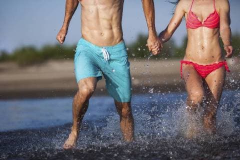 Couple holding hands splashing in water model released Symbolfoto  VPIF00005