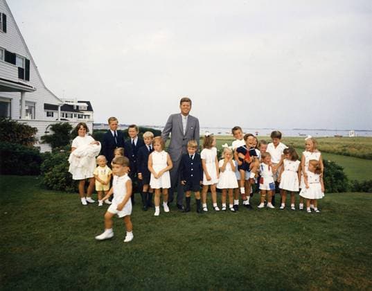 President John F. Kennedy with children, Kathleen Kennedy (holding Christopher Kennedy) Edward Kennedy Jr.,Joseph P. Kennedy II, Kara Kennedy, Robert F. Kennedy Jr., David Kennedy, Caroline Kennedy, President Kennedy, Michael Kennedy, Courtney Kennedy, Kerry Kennedy, Bobby Shriver (holding Timothy Shriver), Maria Shriver, Steve Smith Jr., Willie Smith, Christopher Lawford, Victoria Lawford, Sidney Lawford, Robin Lawford (in foreground- John F. Kennedy Jr.). Hyannisport, MA, Kennedy Compound, August 3, 1963. Photo by Cecil Stoughton NARA  Copyright: xCecilxStoughtonx xNARAx 1003_749THA