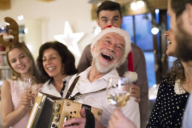 Senior man playing accordion for happy family at Christmas model released Symbolfoto property released  HAPF02217