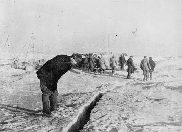 SS Chelyuskin , a Soviet steamship sent out on an expedition to navigate through polar ice along the Northern Maritime Route from Murmansk to Vladivostok , has became ice-bound in Arctic waters during navigation . It was caught in the ice fields in September. After that it drifted in the ice pack before sinking on February 13 , 1934, crushed by the icepacks near Kolyuchin Island in the Chukchi Sea . The crew managed to escape onto the ice and built a makeshift airstrip using only a few spades , ice shovels and two crowbars , which helped in the rescue of the crew . Fifty three men walked over the ice with stores on husky sleds . Photo shows ; A member of the expedition looking at fissures in the ice 24 March 1934, Russia Federation Copyright: Topfoto  UnitedArchivesEU038091