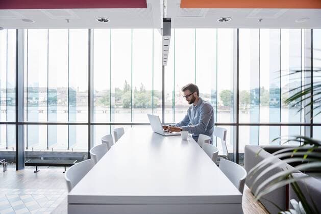 Man using laptop sitting at conference table in office model released Symbolfoto property released  DIGF02722
