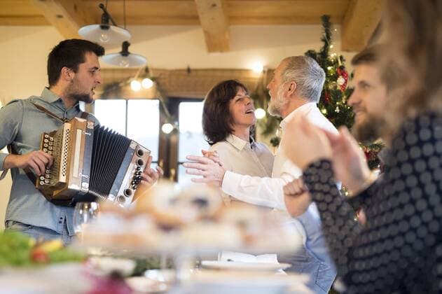 Young man playing accordion for family at Christmas model released Symbolfoto property released  HAPF02208