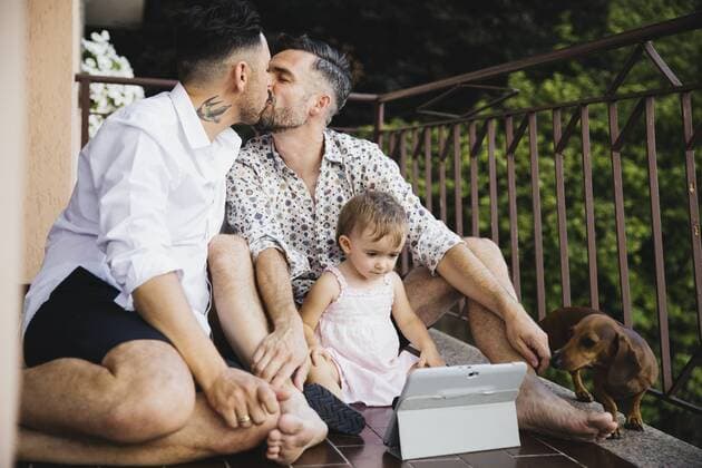 Gay couple kissing with daughter and dog on balcony model released Symbolfoto property released  MRAF00242