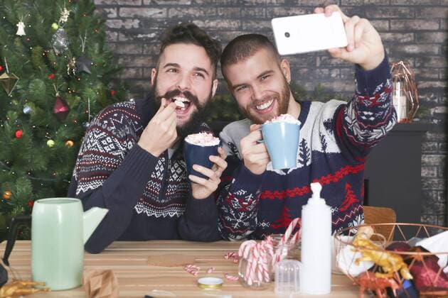 Happy gay couple taking selfie with smartphone at Christmas time at home model released Symbolfoto property released  RTBF01041