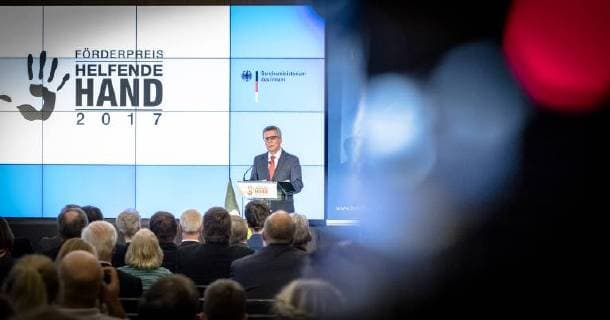 Helping Hand 2017 Federal Minister of the Interior Thomas de Maiziere Federal Minister of the Interior Dr Thomas de Maiziere awards the Foerderpreis Helfende Hand 2017 in Berlin This years Foerderpreis is awarded to ideas and concepts that arouse peoples interest in volunteering in population protection