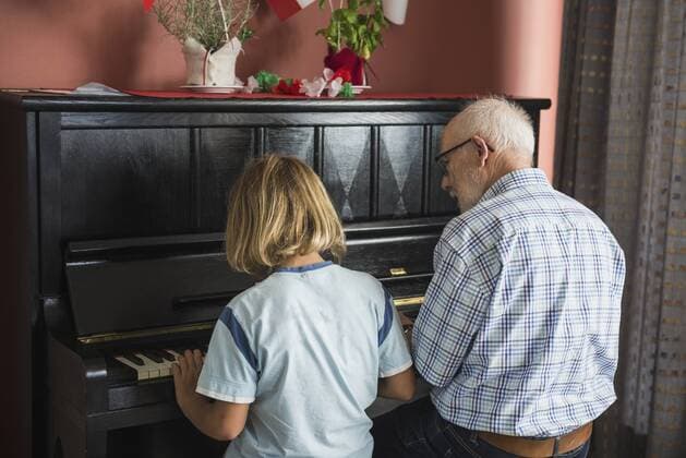 IMAGO Creative: Bildung, Musikerziehung Grandfather and grandson playing piano instrument, Eichenau, Bavaria, Germany mit_2017_10079