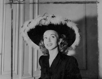 American film star Carole Landis pictured wearing a black satin two-piece suit, which shows a skirt of slightly longer cut. Her large brimmed black satin hat is trimmed with pink ostrich feathers. Pink suede gloves with black markings and black satin shoes complete the ensemble designed by Castillo of Elizabeth Arden. 8 October 1947, London United Kingdom England Copyright: Topfoto  !ACHTUNG AUFNAHMEDATUM GESCHÄTZT! UnitedArchives1371233
