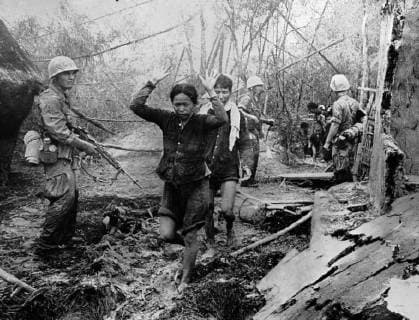 IMAGO History, Vietnamkrieg: 1955-1975 Woman Suspect. Qui Nhon, South Vietnam : United States marines usher Viet Cong suspects - one of them a woman - through the rubble of a village north of Qui Nhon as they sweep the area in a clearing operation. The multi pronged Marine plan was designed to secure the perimeter around their coastal base in the Highlands. 10 September 1965, Viet Nam Copyright: Topfoto  !ACHTUNG AUFNAHMEDATUM GESCHÄTZT! UnitedArchives1398090