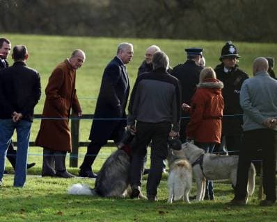 Prince Philip, Duke of Edinburgh, behind Prince Andrew, Duke of York, looks at some large dogs on his way to the St. Mary Magdalene Church Sunday morning service, on Christmas Eve, in Sandringham, Norfolk, on December 24, 2017. 