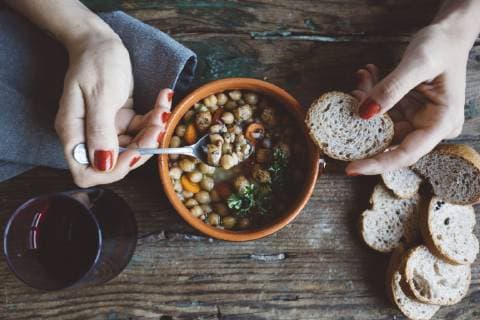IMAGO Nature: Unsere Erde, Klimawandel, Ernährung, Pflanzen der Zukunft, Kichererbse Woman eating Mediterranean soup with bread, close-up model released Symbolfoto  GIOF03299