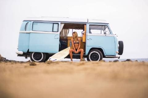 Young woman with surfboard sitting in van on the beach model released Symbolfoto  SIPF01803