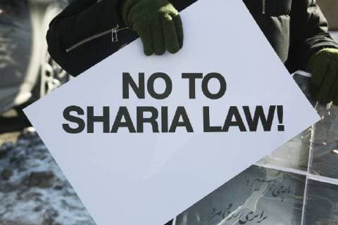 January 6, 2018 - Toronto, Ontario, Canada - Protestor holds a sign saying No to Sharia law as hundreds of Canadians take part in a protest against the Islamic Republic of Iran in Toronto, Ontario, Canada, on January 06, 2018. Protestors showed their solidarity with anti-government demonstrators in Iran and their support of a national uprising of the Iranian people. Protesters called for a regime change for social justice and freedom and democracy in Iran. There was a also a call that power in Iran be returned to Reza Pahlavi, the former Crown Prince of Iran and the last heir apparent to the defunct throne of the Imperial State of Iran and the current head of the exiled House of Pahlavi. Toronto Canada  - ZUMAn230 20180106_zaa_n230_1121 Copyright: xCreativexTouchxImagingxLtdx
