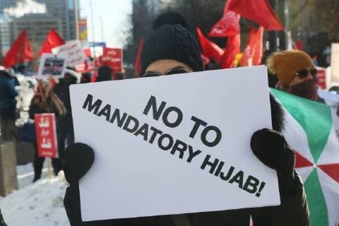 January 6, 2018 - Toronto, Ontario, Canada - Protestor holds a sign saying No to Mandatory Hijab as hundreds of Canadians take part in a protest against the Islamic Republic of Iran in Toronto, Ontario, Canada, on January 06, 2018. Protestors showed their solidarity with anti-government demonstrators in Iran and their support of a national uprising of the Iranian people. Protesters called for a regime change for social justice and freedom and democracy in Iran. There was a also a call that power in Iran be returned to Reza Pahlavi, the former Crown Prince of Iran and the last heir apparent to the defunct throne of the Imperial State of Iran and the current head of the exiled House of Pahlavi. Toronto Canada  - ZUMAn230 20180106_zaa_n230_1127 Copyright: xCreativexTouchxImagingxLtdx