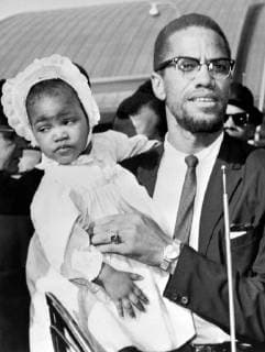 IMAGO History, U.S. Bürgerrechtsbewegung: 1954-1968 23 MAY 1964 Warrant out for Malcolm X s arrest. Malcolm X, the Militant Black Nationalist Movement Leader, carries his daughter Ilyasah as he is pictured on his arrival at the John F. Kennedy airport here, 21st May, following a tour of the Middle East. Malcolm X returned to find a warrant for his arrest has been issued the day previous to his arrival. The warrant was issued when he failed to turn up at the traffic court to answer a speeding charge. New York, USA, New York City New York United States Copyright: Topfoto  UnitedArchivesIPU477420