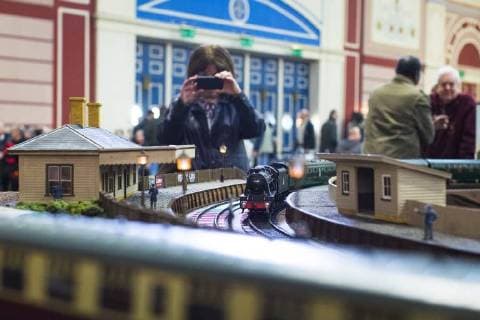 January 19, 2018 - London, London, UK - London, UK. An enthusiast films on her mobile phone as a Gauge 1 steam locomotive passes through a miniature station at the London Model Engineering Exhibition at Alexandra Palace. Over 50 clubs and societies are exhibiting nearly 2,000 models constructed by their members. London UK  - ZUMAl94_ 20180119_zaf_l94_019 Copyright: xRobxPinneyx