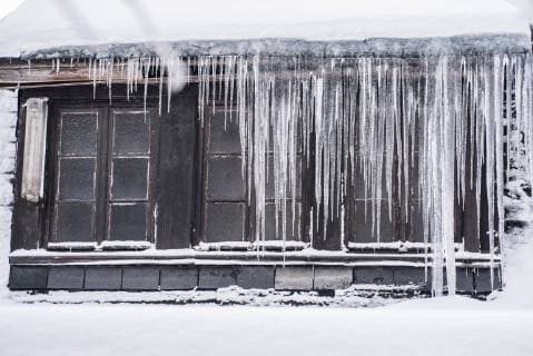 Icicles hanging down from a roof top in winter  IPF00435