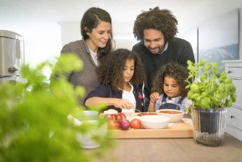 IMAGO Creative: Digitale Welt, Verzicht auf Technologie Family baking pizza in kitchen, daughter spreading tomato sauce model released Symbolfoto property released  MOEF00300