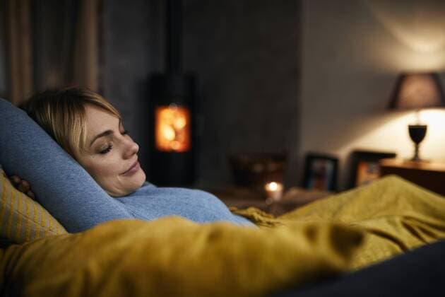 Portrait of smiling woman relaxing on couch at home in the evening model released Symbolfoto property released  RBF06211