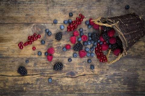 Wickerbasket of various berries on wood  LVF06565