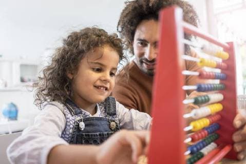 Father sitting at table with his daughter learning to caculate with a slide rule model released Symbolfoto property released  MOEF00298