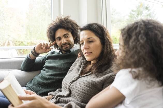 Happy family sitting on couch, reading book model released Symbolfoto property released  MOEF00350