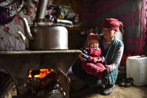 (180203) -- ILI, Feb. 3, 2018 -- A herder holds her daughter to warm themselves by a stove at home in Akyaz Valley, Zhaosu County, northwest China s Xinjiang Uygur Autonomous Region, Jan. 15, 2018. About 130 kilometers from the nearest town, Akyaz Valley is an important winter grazing place for herders in Zhaosu County, Xinjiang. Despite an altitude of 2,000 meters, the Akyaz Valley has a warmer climate than surrounding areas and abundant grass and water. It is sometimes referred to as the valley of life. For centuries, herding has been an ancestral tradition for nomadic Kazakhs in Zhaosu. Migration begins in October, and more than 10,000 people drive 400,000 cattle and sheep to their winter homes, not leaving until May the next year. ) (wyo)(zt) CHINA-XINJIANG-AKYAZ VALLEY-WINTER GRAZING (CN) HuxHuhu 