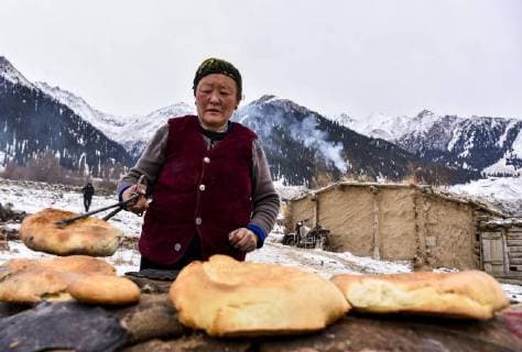 (180203) -- ILI, Feb. 3, 2018 -- A herder makes naan bread, a local snack, in Akyaz Valley, Zhaosu County, northwest China s Xinjiang Uygur Autonomous Region, Jan. 15, 2018. About 130 kilometers from the nearest town, Akyaz Valley is an important winter grazing place for herders in Zhaosu County, Xinjiang. Despite an altitude of 2,000 meters, the Akyaz Valley has a warmer climate than surrounding areas and abundant grass and water. It is sometimes referred to as the valley of life. For centuries, herding has been an ancestral tradition for nomadic Kazakhs in Zhaosu. Migration begins in October, and more than 10,000 people drive 400,000 cattle and sheep to their winter homes, not leaving until May the next year. ) (wyo)(zt) CHINA-XINJIANG-AKYAZ VALLEY-WINTER GRAZING (CN) HuxHuhu 