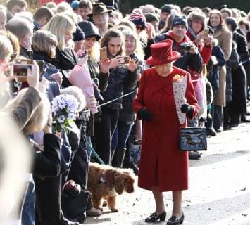 Bilder des Tages HM Queen Elizabeth II is given bunches of flowers, before a dog gets curious and takes a closer look at HM Queen Elizabeth II s shoes after attending the Sunday morning service at St Peter and St Paul church at West Newton, Norfolk, on February 4, 2018. 