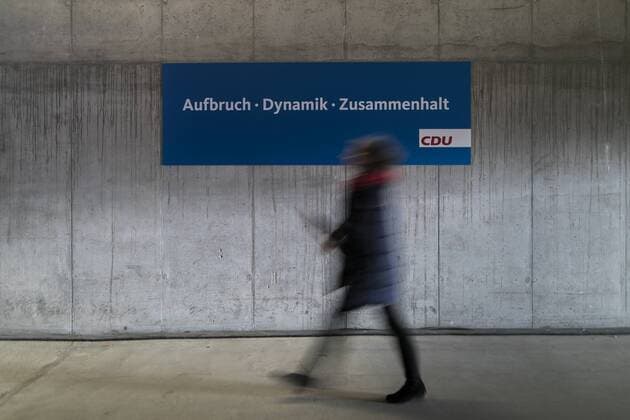 A woman walks along a sign reading Aufbruch Dynamik Zusammenhalt at the 30th party congress of the CDU Germany in Berlin 26 02 2018 Berlin Germany Copyright: xFlorianxGaertner photothek.netx