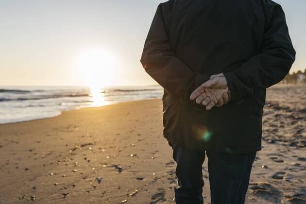 Senior man strolling at the beach, rear view model released Symbolfoto  JRFF01521