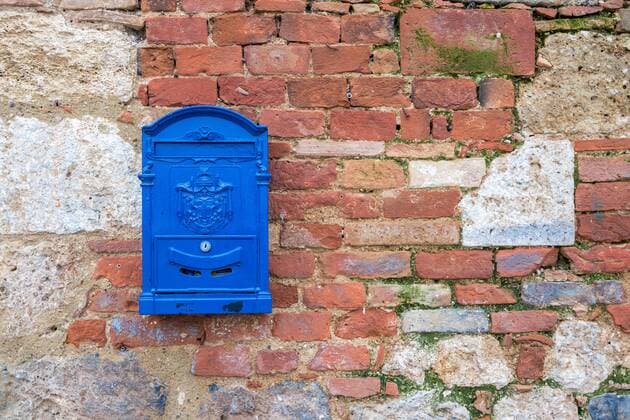 Blue letterbox on brick wall in the municipality of Monteriggioni in the province of Siena in Tuscany Tuscany Italy