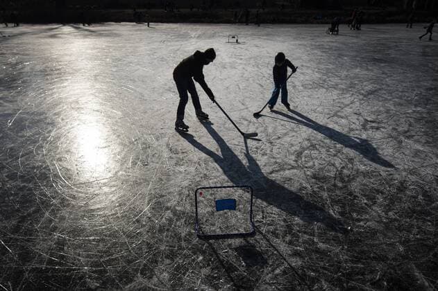 Eine erwachsene Person und ein Kind spielen Eishockey auf einem zugefrorenen Teich in Potsdam, 03.03.2018. Potsdam Deutschland *** An adult person and a kid play ice hockey on a frozen pond in Potsdam 03 03 2018 Potsdam Germany Copyright: xFlorianxGaertner photothek.netx