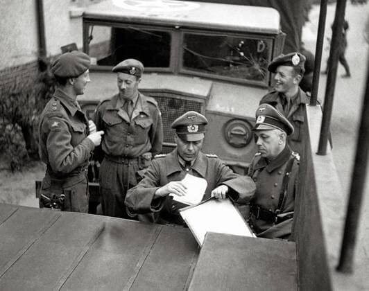 Officers of the 2 British Army and 2 Wehrmacht officers negotiate the agreement on the transfer of the neutral territory of the Bergen Belsen camp to the British army. The 11th Panzer Division then occupied the concentration camp on 15 April 1945 Bergen Belsen Germany Date 12 April 1945
