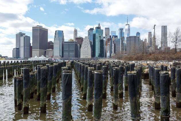 United States of America New York New York 16 03 2018 View from Brooklyn Bridge Park and piles of disused port facilities onto the Manhattan skyline and financial district
