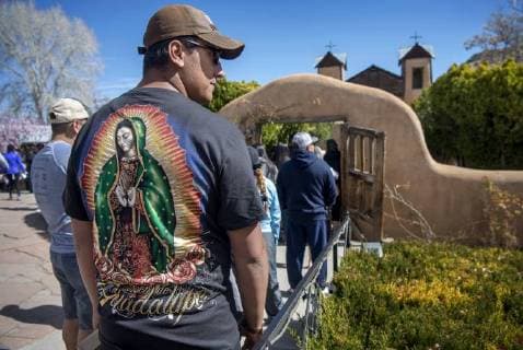 March 30, 2018 - U.S. - Jonmykel Garcia, from Los Lunas, wears a new Our Lady of Guadalupe shirt as he waits in line to enter the Santuario de Chimayo. Thousands of people were making their Good Friday pilgrimage to the Northern New Mexico Church, Friday March 30, 2018. U.S. - ZUMAab1_ 20180330_zaf_ab1_005 Copyright: xEddiexMoorex