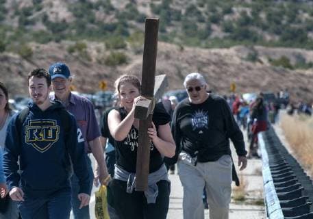 March 30, 2018 - U.S. - Aidan Vrazel, 21, and Elizabeth Anaya, 19, center, from Denver, but with a group from Immaculate Heart of Mary Catholic Church in Los Alamos, carry a large cross as they make their way to the Santuario de Chimayo. Thousands of people were making their Good Friday pilgrimage to the Northern New Mexico Church, Friday March 30, 2018. U.S. - ZUMAab1_ 20180330_zaf_ab1_004 Copyright: xEddiexMoorex