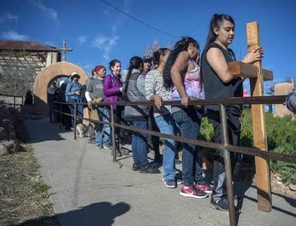 March 30, 2018 - U.S. - Jasmin Perez, 17, from Espanola, waits in line with her cross to enter the Santuario de Chimayo. Thousands of people were making their Good Friday pilgrimage to the Northern New Mexico Church, Friday March 30, 2018. Perez had walked from Santa Cruz. U.S. - ZUMAab1_ 20180330_zaf_ab1_013 Copyright: xEddiexMoorex