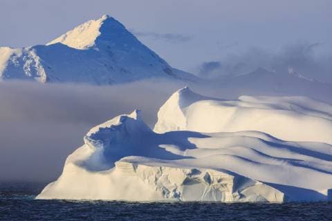 Huge non-tabular iceberg, mountains, evening light and mist, Bransfield Strait, South Shetland Islands, Antarctica, Polar Regions Copyright: EleanorxScriven 1167-1657