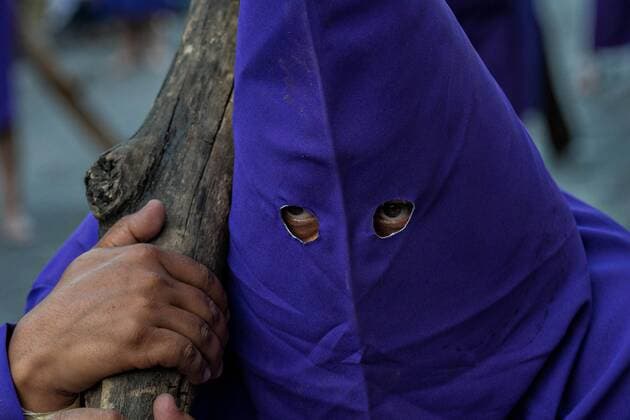 March 31, 2018 - QuereTaro, Queretaro, Mexico - A hooded penitent carries a heavy wooden cross through the city streets during the Procession of Silence as part of Holy Week March 30, 2018 in Queretaro, Mexico. The penitents, known as Nazarenes, carry heavy crosses and drag chains in a four hour march to recreate the pain and suffering during the passion of Christ. QuereTaro Mexico - ZUMAe02_ 20180331_zaf_e02_006 Copyright: xRichardxEllisx