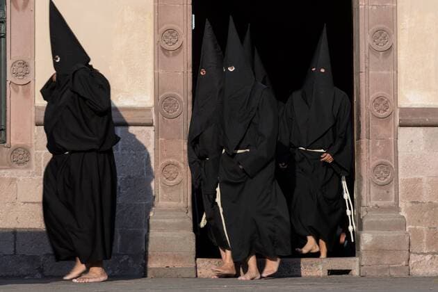 March 31, 2018 - QuereTaro, Queretaro, Mexico - Hooded penitents walk out from the Church of the Holy Cross at the start of the Procession of Silence as part of Holy Week March 30, 2018 in Queretaro, Mexico. The penitents, known as Nazarenes, carry heavy crosses and drag chains in a four hour march to recreate the pain and suffering during the passion of Christ. QuereTaro Mexico - ZUMAe02_ 20180331_zaf_e02_003 Copyright: xRichardxEllisx