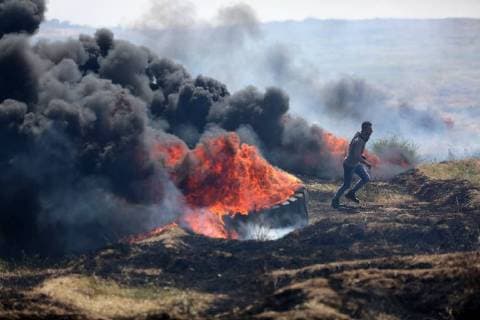 April 6, 2018 - Gaza, gaza strip, Palestine - Palestinian protestors gesture during clashes with Israeli security forces on the Gaza-Israel border following a protest calling for the right to return, east of Gaza City on April 6, 2018. Clashes erupted on the Gaza-Israel border a week after similar demonstrations led to violence in which Israeli force killed 19 Palestinians, the bloodiest day since a 2014 war. Gaza null  - ZUMAn230 20180406_zaa_n230_284 Copyright: xMajdixFathix