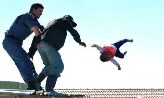 Themen der Woche KW15 Bilder des Tages Father nabbed after flinging daughter off shack roof PORT ELIZABETH, SOUTH AFRICA ? APRIL 12: A man scuffles with a police officer as he flings his six-month-old baby off the roof of a shack at the Joe Slovo informal settlement on April 12, 2018 in Port Elizabeth, South Africa. The man who flung his child while resisting the demolition of an illegal structure was arrested and charged with attempted murder. A group of policemen who had surrounded the shack managed to catch the baby. ( Gallo0000263983