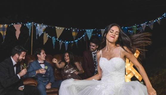 Happy bride dancing on a night field party with groom and friends in the background model released Symbolfoto property released  DAPF00936