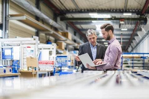 Businessmen using laptop in production hall model released Symbolfoto property released  DIGF03489