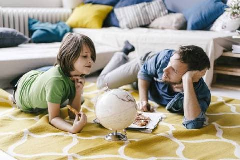 Father and son eating pizza next to globe on the floor at home model released Symbolfoto property released  KNSF03621
