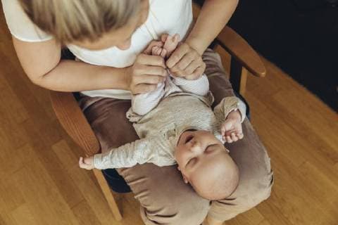Mother holding up baby™s feet to help with digestion model released Symbolfoto property released  MFF04399
