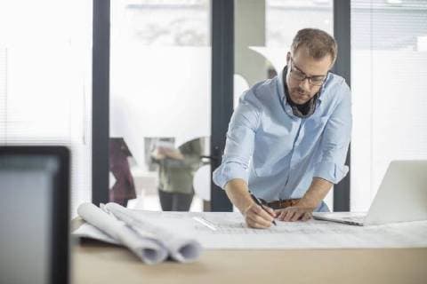 Man making notes on plan in office model released Symbolfoto property released  ZEF15051